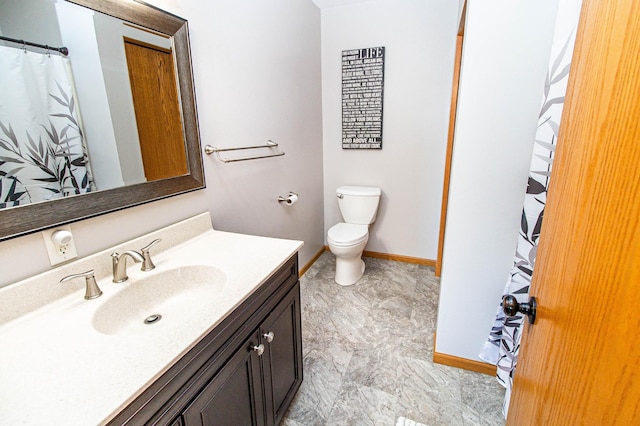 full bath with toilet, vanity, and baseboards