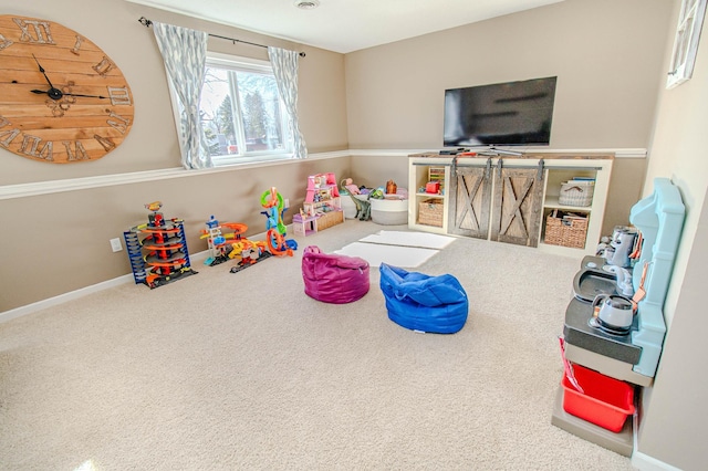 recreation room with baseboards and carpet