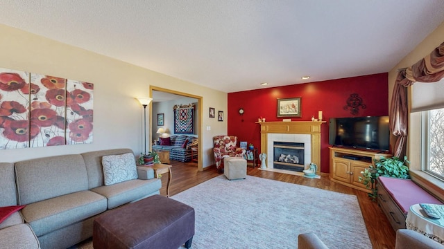 living area with wood finished floors and a tile fireplace