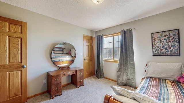 bedroom featuring a textured ceiling, baseboards, and light carpet