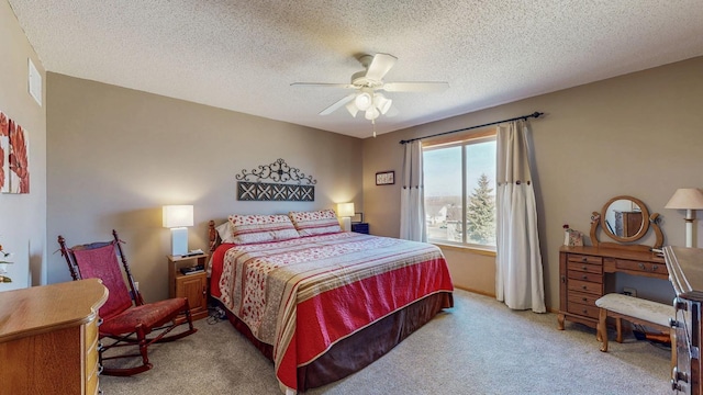 carpeted bedroom featuring a ceiling fan, visible vents, and a textured ceiling