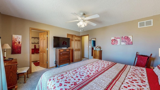 carpeted bedroom with a ceiling fan, visible vents, and a textured ceiling