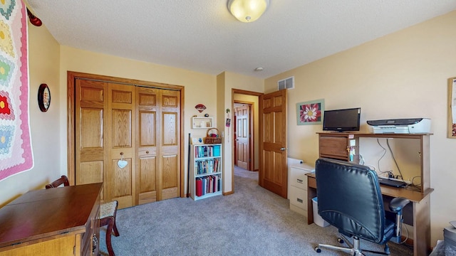 home office featuring visible vents, light colored carpet, and a textured ceiling