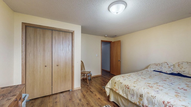 bedroom with baseboards, wood finished floors, a closet, and a textured ceiling