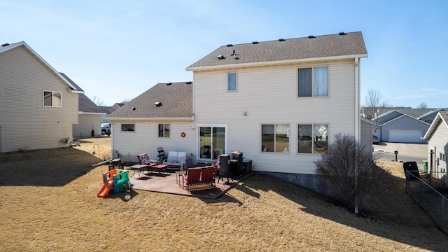 back of property with a patio area, a shingled roof, and fence