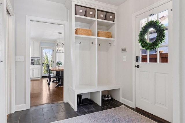 mudroom featuring a notable chandelier and baseboards