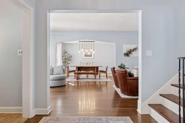 interior space with stairway, baseboards, an inviting chandelier, and wood finished floors