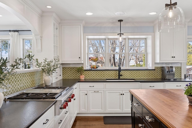 kitchen featuring white cabinets, butcher block countertops, stainless steel gas cooktop, and a sink