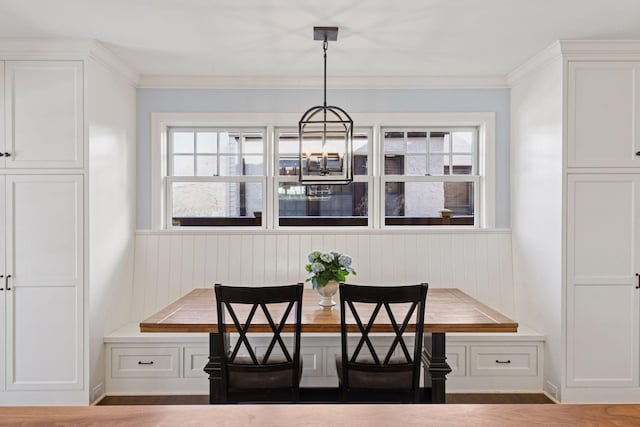 dining room with breakfast area, a notable chandelier, and ornamental molding