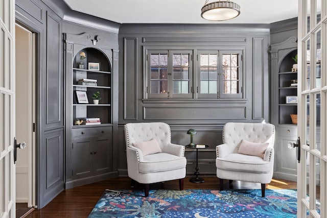 living area with dark wood finished floors, french doors, and built in shelves