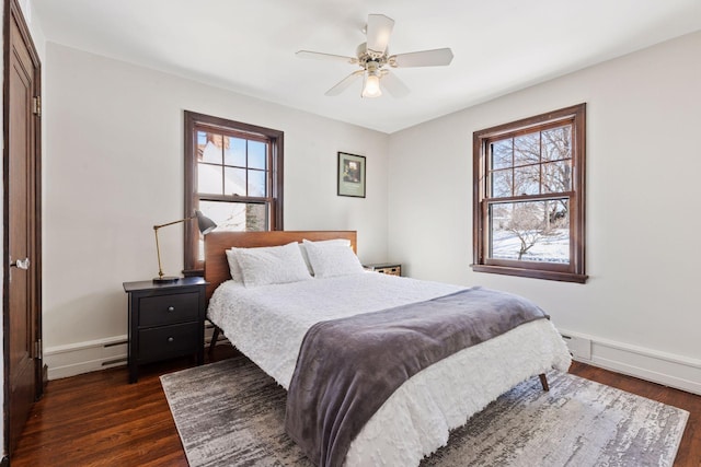 bedroom featuring a baseboard radiator, baseboards, dark wood finished floors, and a ceiling fan