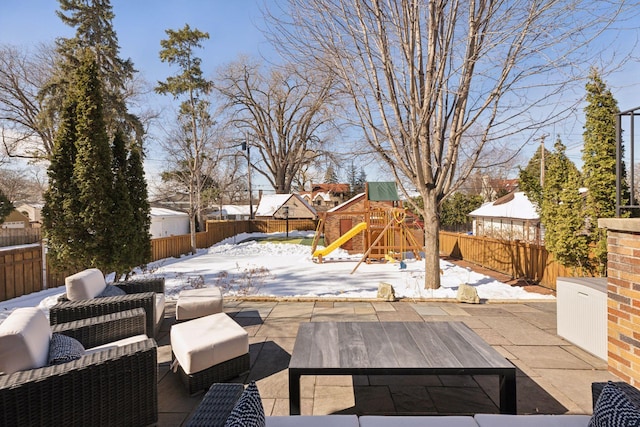 snow covered patio featuring an outdoor hangout area, a playground, and a fenced backyard