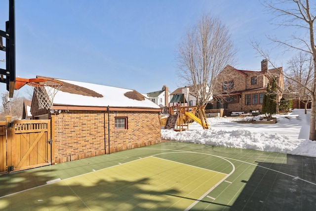 view of basketball court with a playground, a gate, fence, and basketball court