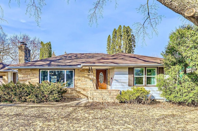 single story home featuring stone siding and a chimney