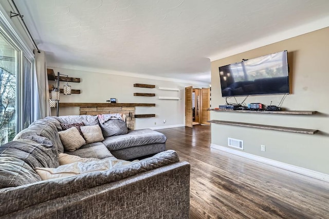 living area featuring visible vents, baseboards, and dark wood-style floors