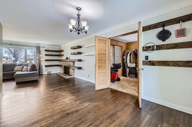 living room featuring a notable chandelier, visible vents, baseboards, and wood finished floors