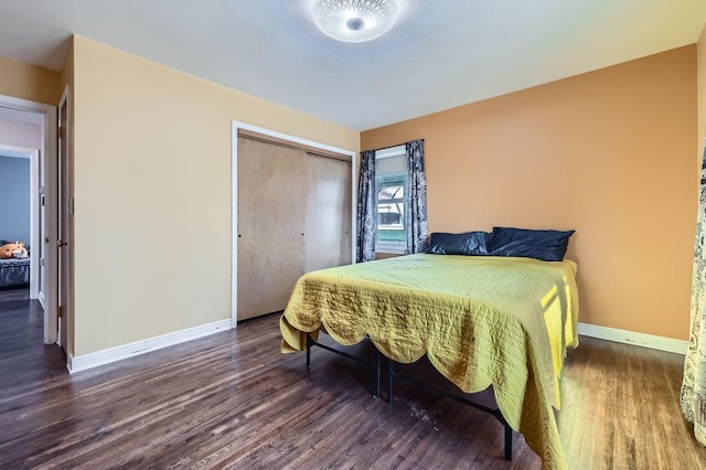 bedroom featuring wood finished floors, baseboards, and a closet