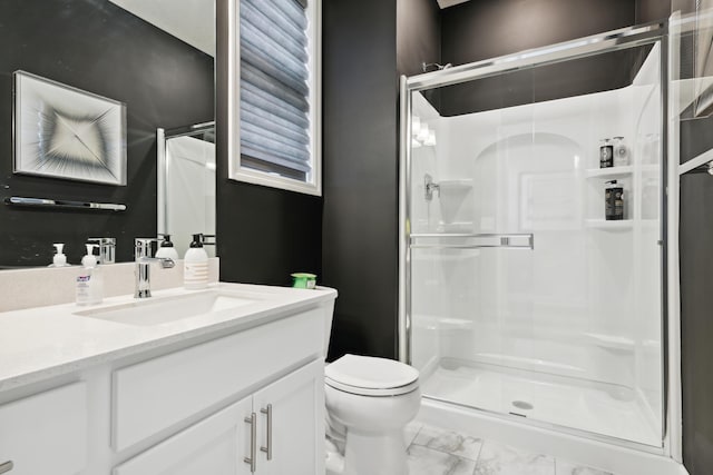 full bath featuring toilet, marble finish floor, a stall shower, and vanity