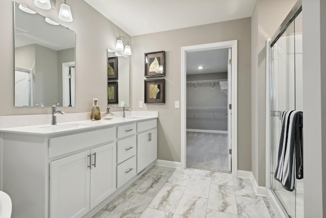 bathroom featuring a sink, baseboards, marble finish floor, and a shower stall