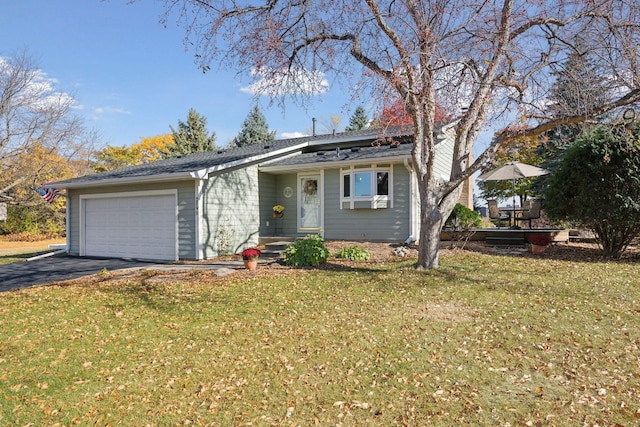 view of front facade with aphalt driveway, an attached garage, and a front lawn