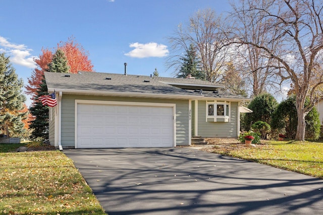 view of front of property with a shingled roof and a front lawn