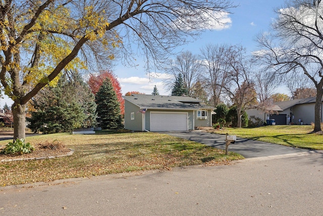 view of front facade featuring a front yard, an attached garage, and driveway