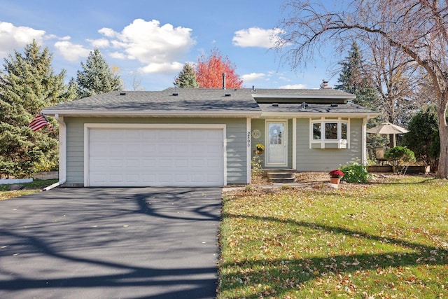 view of front facade with driveway, a front yard, and an attached garage