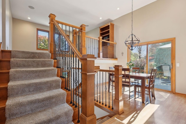 stairs featuring recessed lighting, wood finished floors, baseboards, and a chandelier