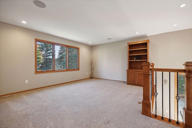 unfurnished room with recessed lighting, light colored carpet, and baseboards