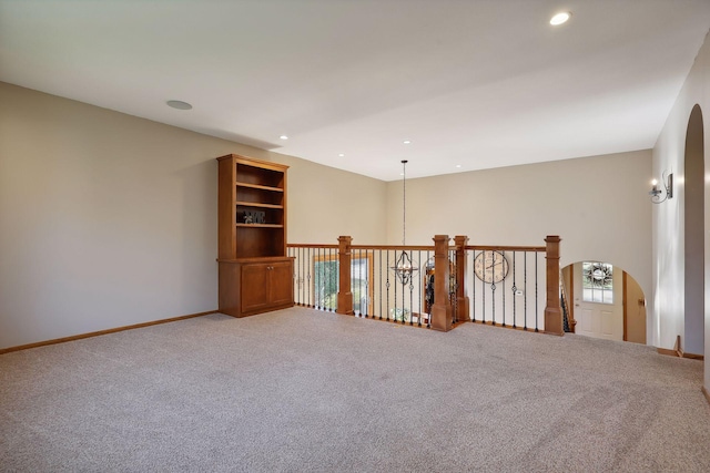 carpeted empty room with arched walkways, recessed lighting, and baseboards