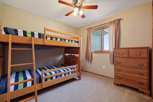 bedroom featuring a textured ceiling, a ceiling fan, baseboards, and light carpet