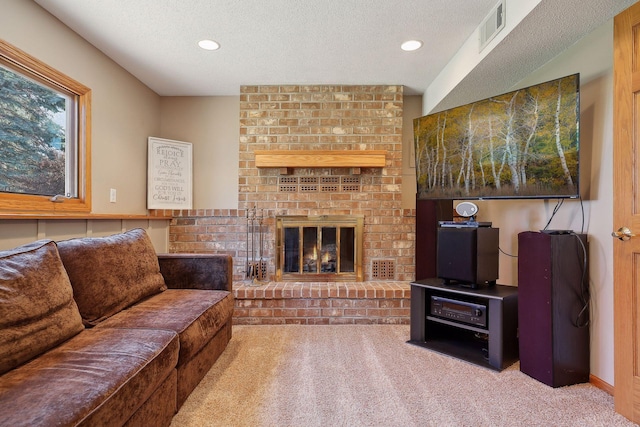 living area with visible vents, carpet floors, a textured ceiling, and a brick fireplace