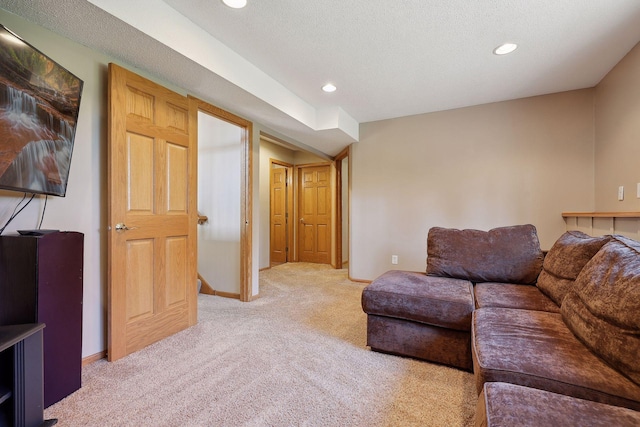 living area with recessed lighting, baseboards, carpet floors, and a textured ceiling