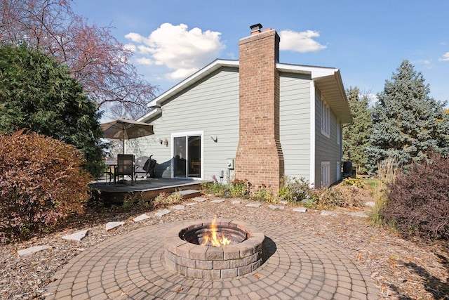 back of house with a patio area, a chimney, and an outdoor fire pit