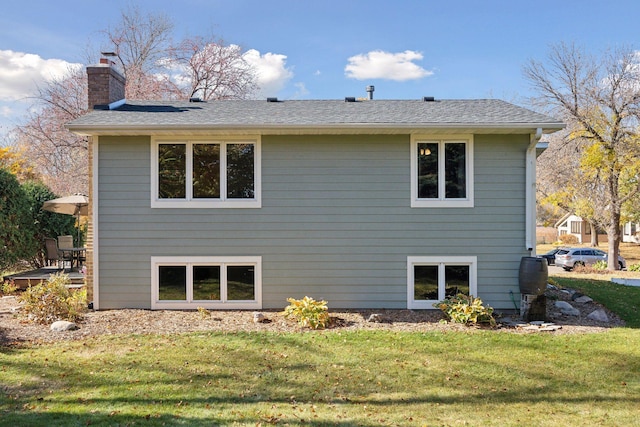 rear view of house with a lawn and a chimney