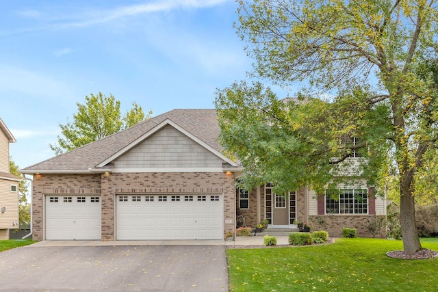 view of front of home with aphalt driveway, an attached garage, brick siding, and a front lawn