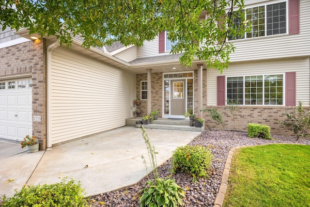 doorway to property featuring brick siding, a shingled roof, and a garage