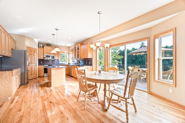 dining area with a notable chandelier, light wood-type flooring, and baseboards