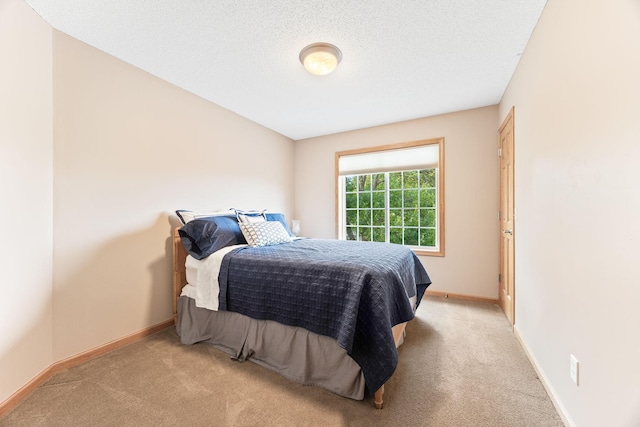 bedroom featuring baseboards, carpet floors, and a textured ceiling