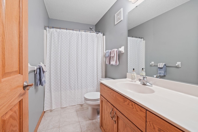 bathroom featuring tile patterned flooring, visible vents, toilet, vanity, and a textured ceiling