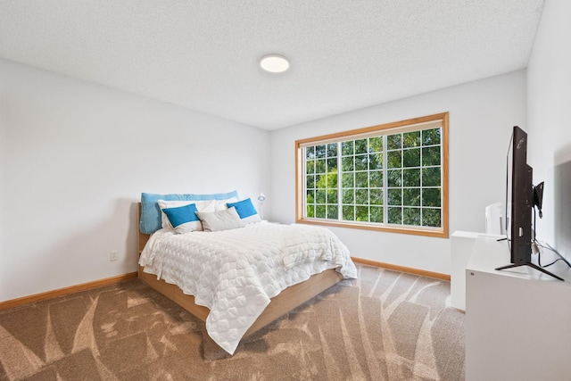 bedroom featuring a textured ceiling, baseboards, and carpet floors