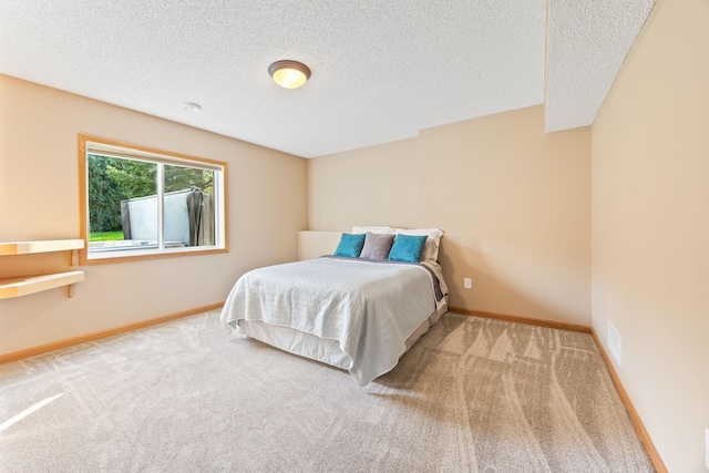 carpeted bedroom featuring visible vents, a textured ceiling, and baseboards