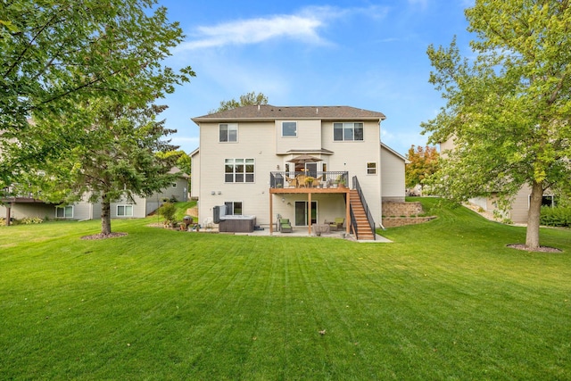 rear view of house featuring a patio, a yard, a wooden deck, stairs, and a hot tub