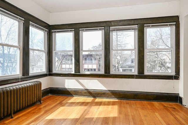 unfurnished sunroom featuring radiator heating unit