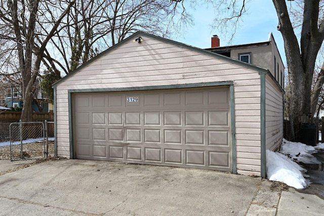 detached garage featuring fence