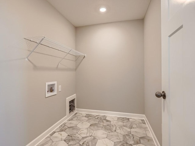 clothes washing area with laundry area, baseboards, and washer hookup