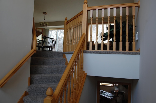 staircase featuring an inviting chandelier