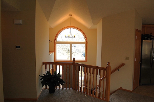 stairway with lofted ceiling, carpet flooring, baseboards, and a chandelier