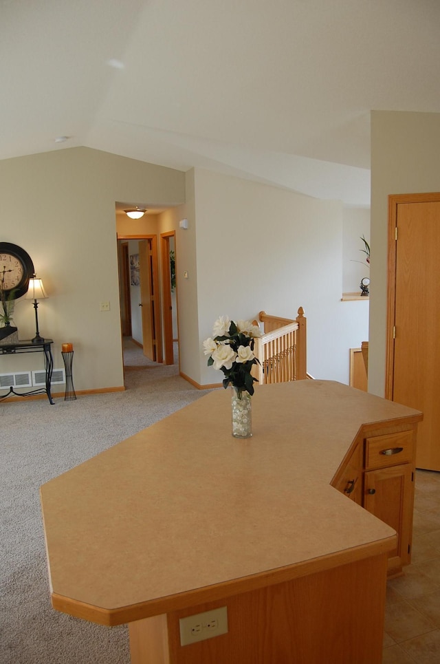 dining room with baseboards, light carpet, and vaulted ceiling