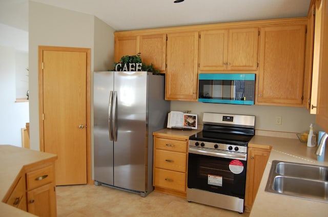 kitchen featuring a sink, appliances with stainless steel finishes, and light countertops